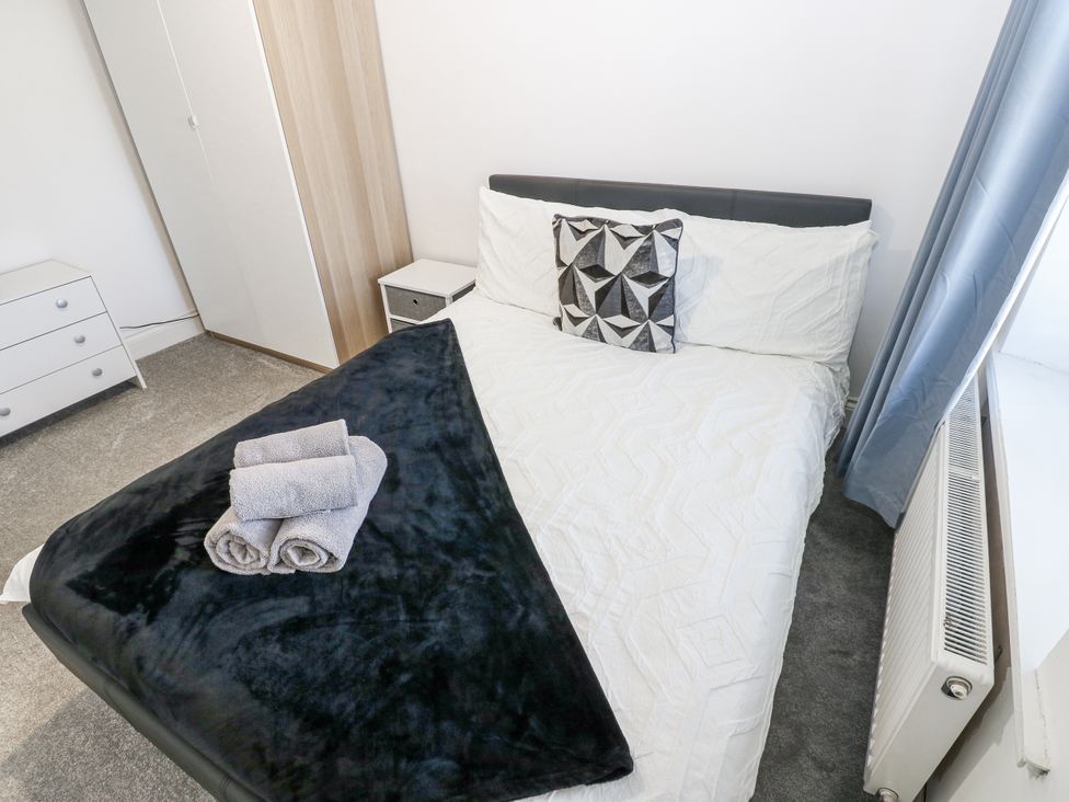 A bedroom with a bed and dresser at Keekle Terrace in Cleator Moor