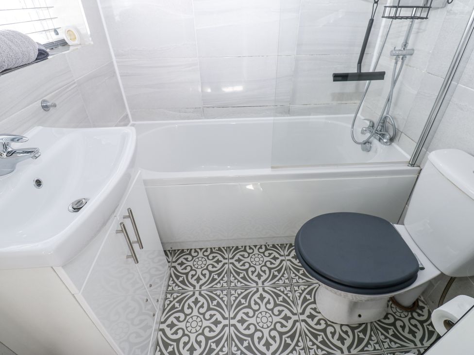 A bathroom with a bathtub, sink, and toilet at Keekle Terrace Cleator Moor