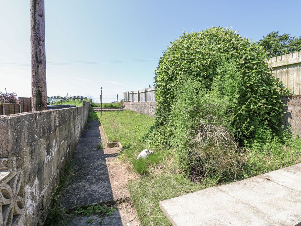 A garden area with a pathway and overgrown vegetation at Keekle Terrace Cleator Moor