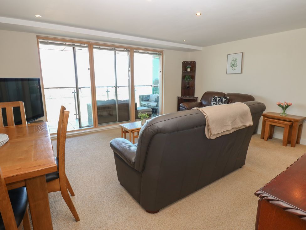 A living room with a sofa and dining area at Pears Suite in Whitehaven