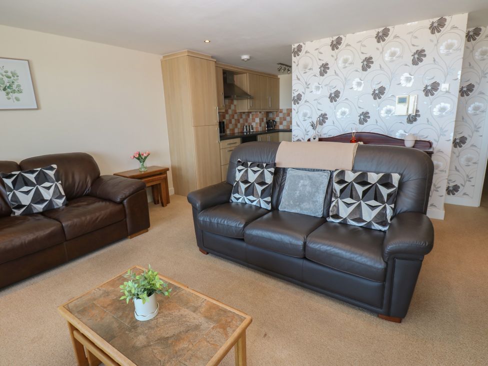 A living room with sofas and a coffee table at Pears Suite in Whitehaven