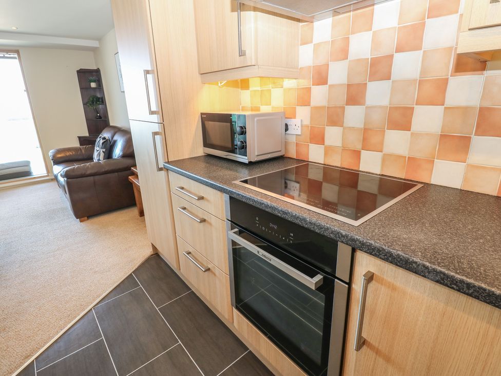 A kitchen with modern appliances and seating area at Pears Suite Whitehaven
