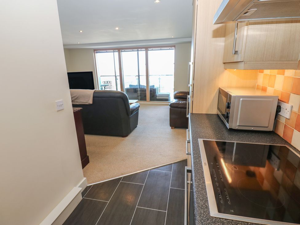 A kitchen with a stove and microwave visible at Pears Suite Whitehaven