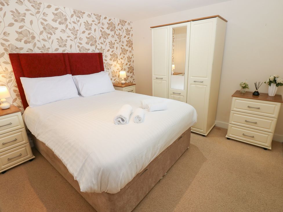 A bedroom with a bed and wardrobe at Pears Suite in Whitehaven