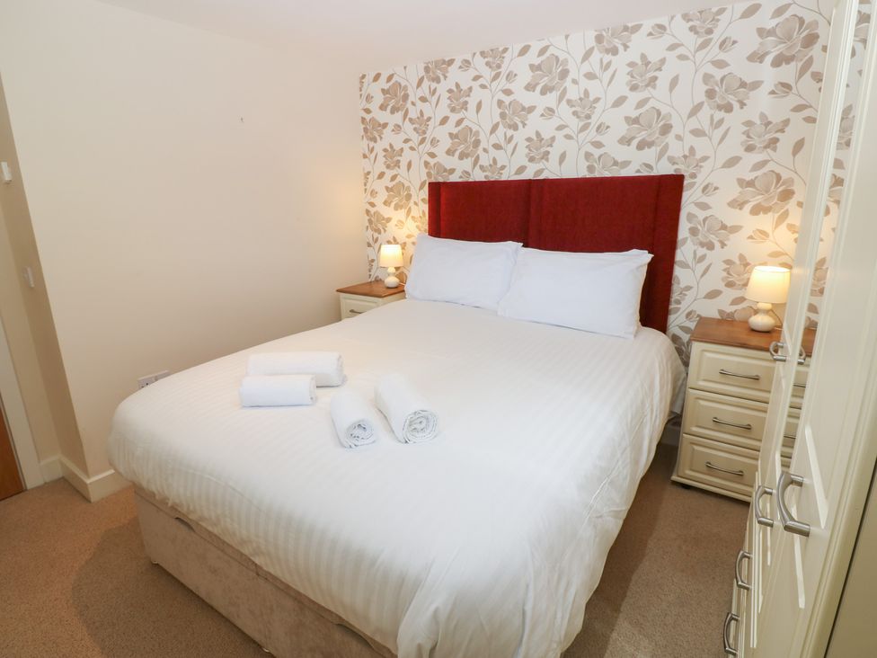 A bedroom with a bed and bedside lamps at Pears Suite, Whitehaven