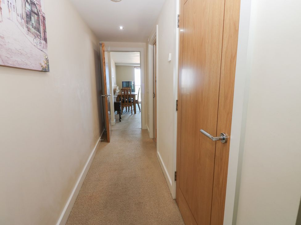 A hallway with a door leading to a dining area at Pears Suite in Whitehaven