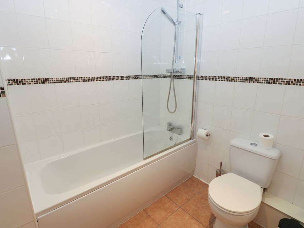A bathroom with a bathtub and toilet at Pears Suite Whitehaven