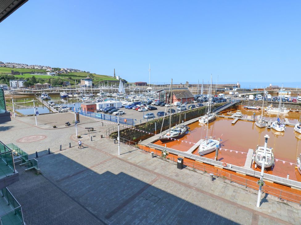 An outdoor view of a harbor with boats and a parking area at Pears Suite Whitehaven