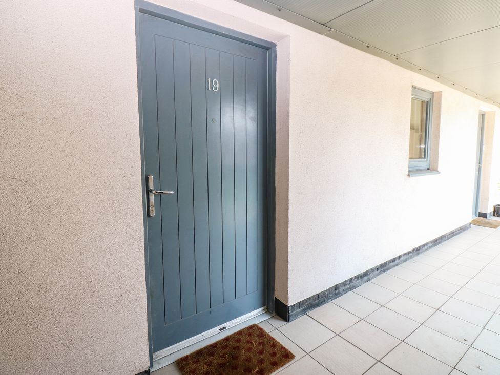 An entrance with a blue door and doormat at Pears Suite in Whitehaven