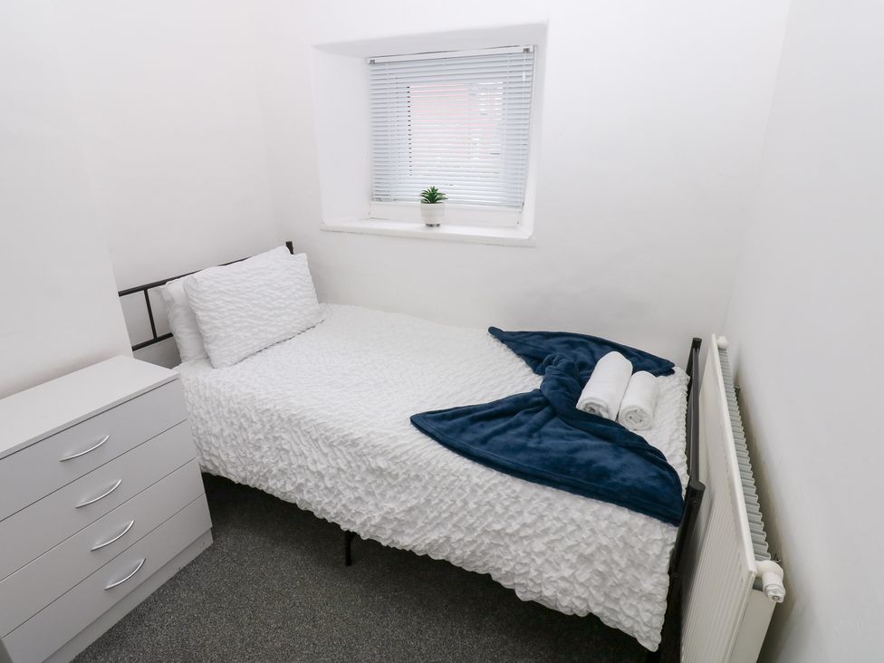 A bedroom with a bed and dresser at Holly House in Waberthwaite