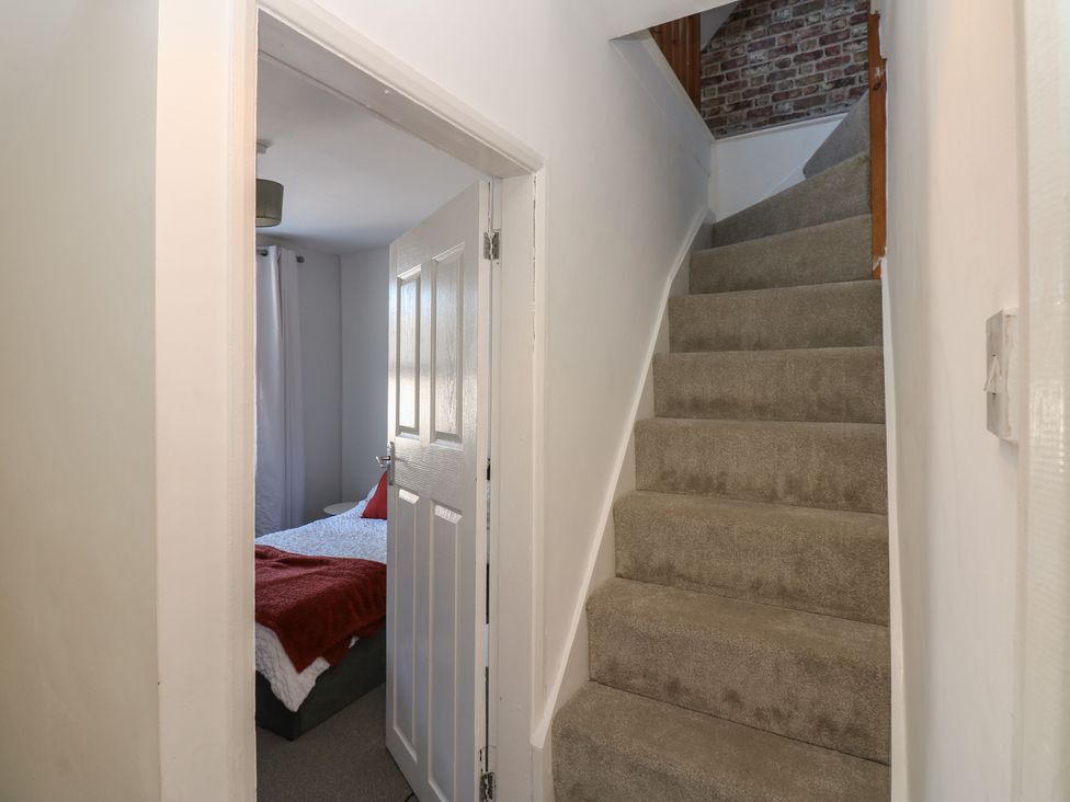A hallway with staircase and a bedroom door at Lonsdale Street