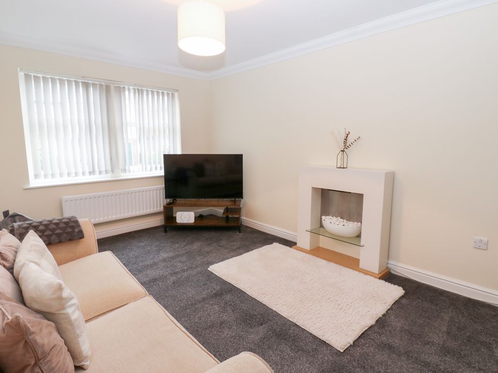 A living room with a television and sofa at Lingla House in Frizington