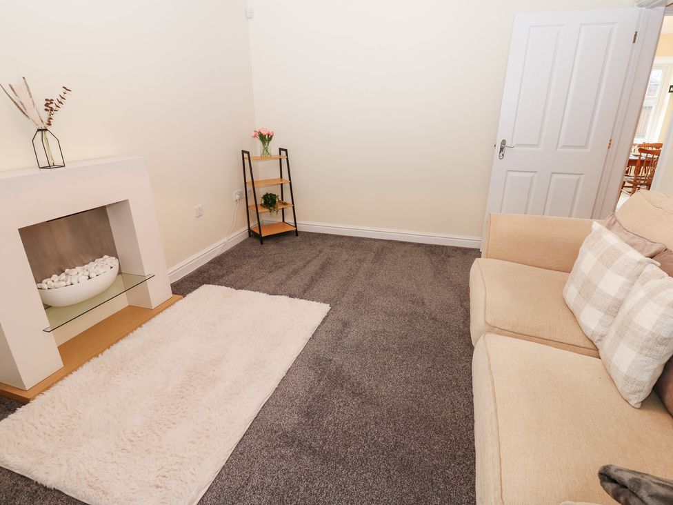 A living room with a sofa and a fireplace at Lingla House in Frizington