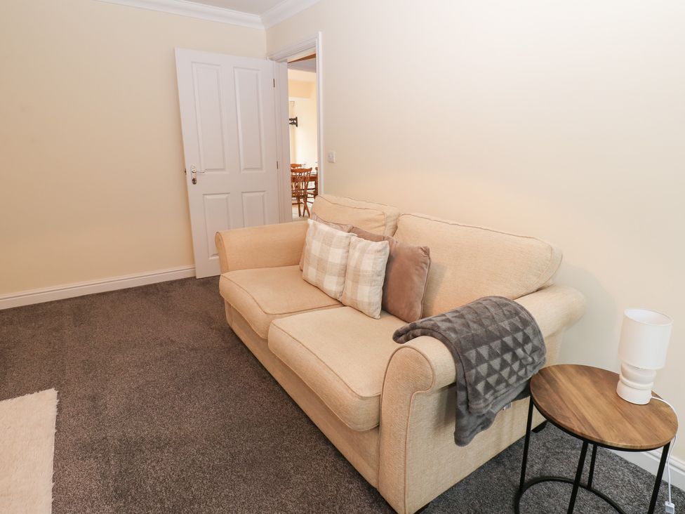 A living room with a sofa and side table at Lingla House in Frizington