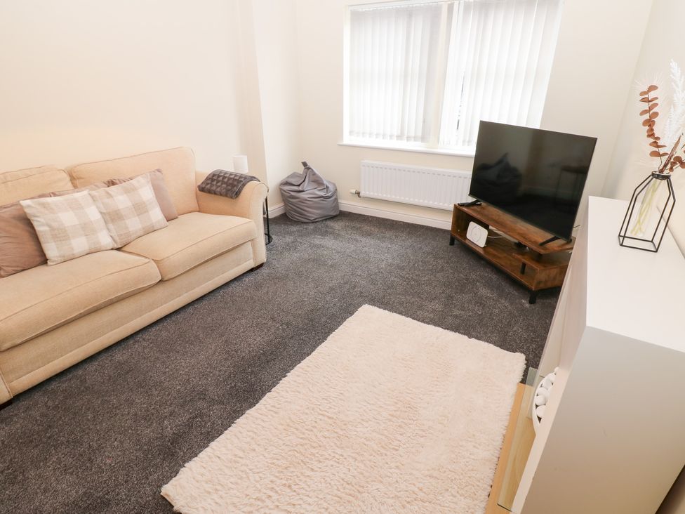 A living room with a sofa and television at Lingla House Frizington