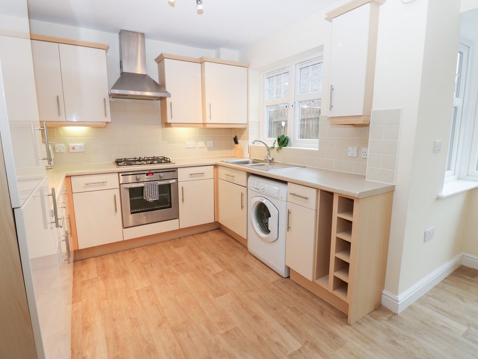 A kitchen with a stove and washing machine at Lingla House in Frizington