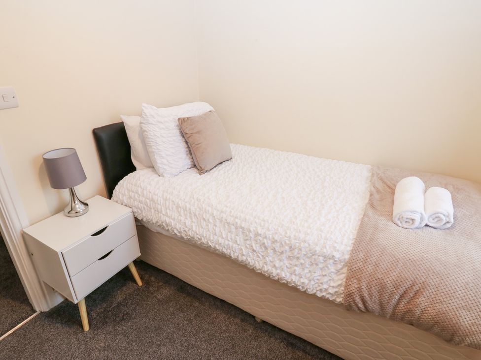 A bedroom with a single bed and a nightstand at Lingla House in Frizington