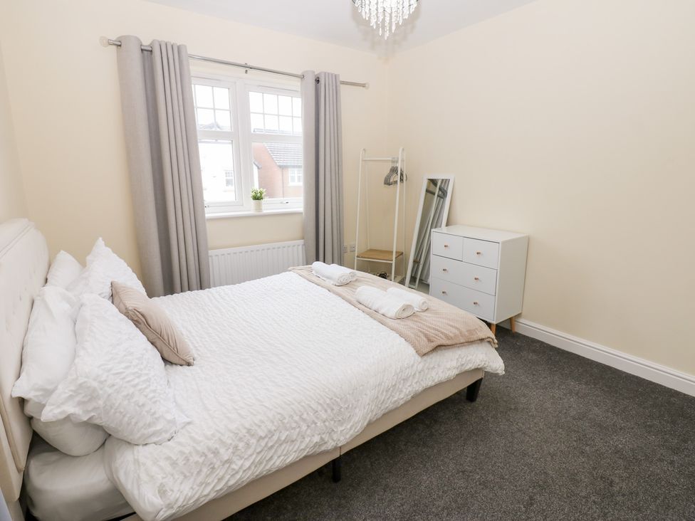 A bedroom with a bed and a mirror at Lingla House in Frizington
