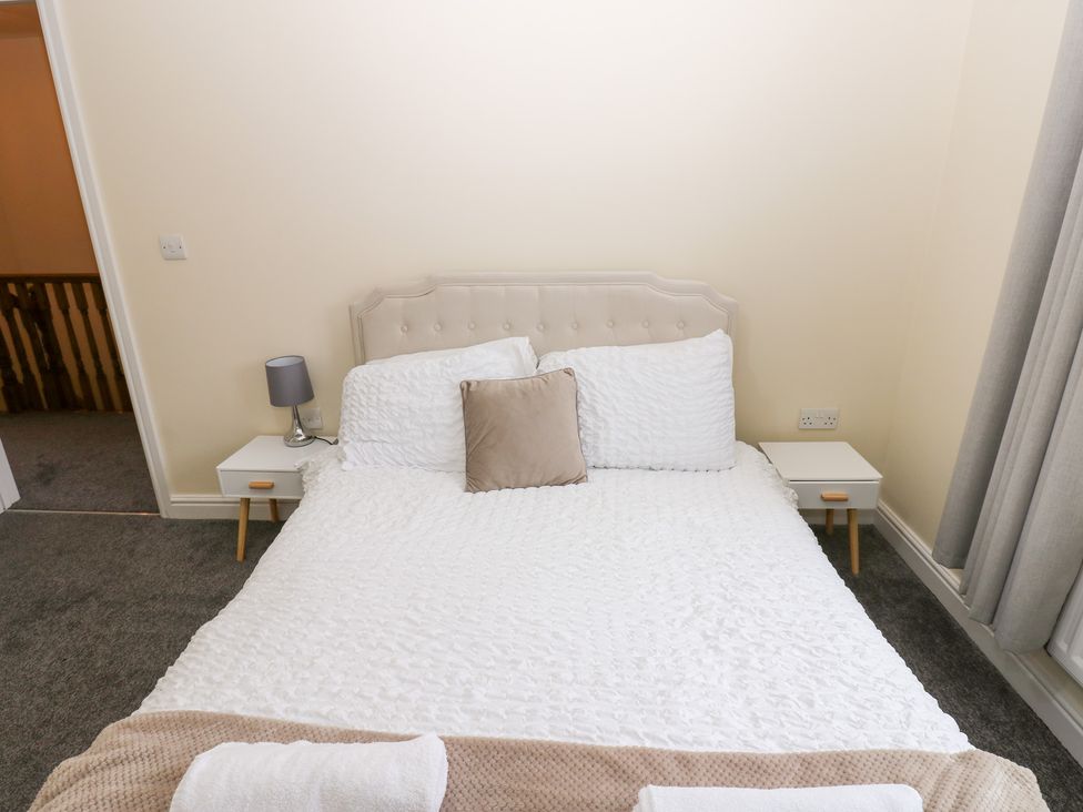 A bedroom with a bed and bedside tables at Lingla House in Frizington