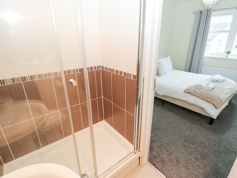 A bathroom with a shower and view of a bedroom at Lingla House in Frizington