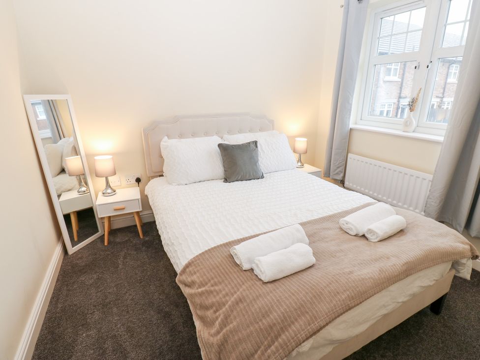A bedroom with a bed and bedside table at Lingla House in Frizington