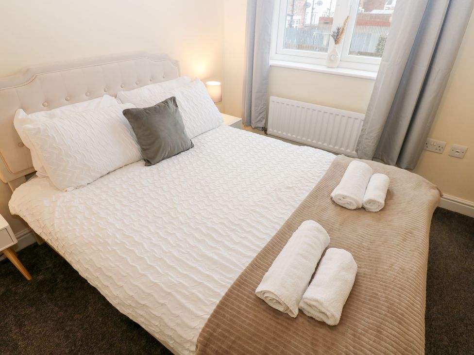 A bedroom with a bed and towels arranged at Lingla House Frizington