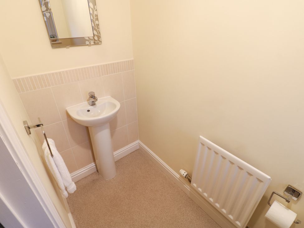 A bathroom with a sink and mirror at Lingla House in Frizington