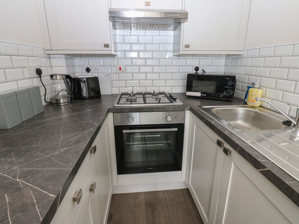 A kitchen with appliances and countertop at Kirkgate Cottage in Cockermouth