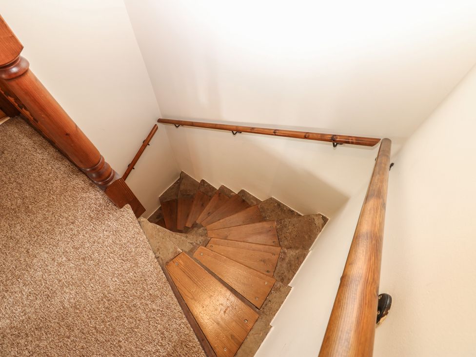 A staircase with wooden steps and a handrail at Kirkgate Cottage Cockermouth