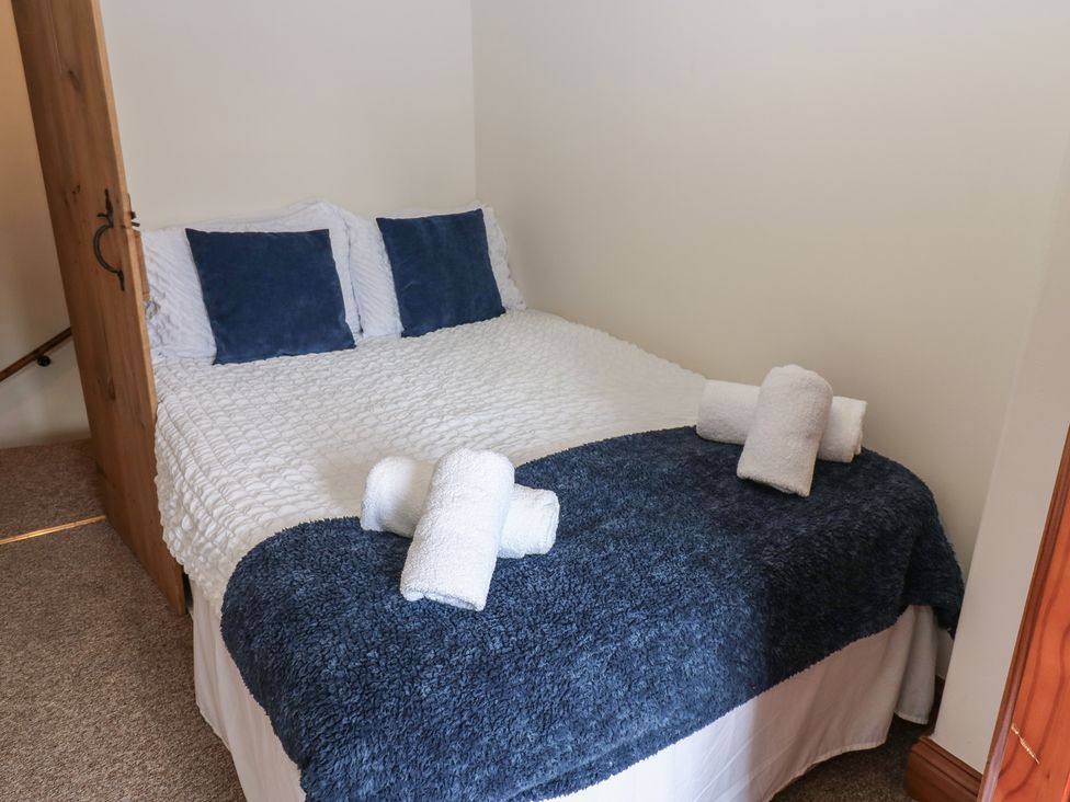 A bed with pillows and towels at Kirkgate Cottage in Cockermouth