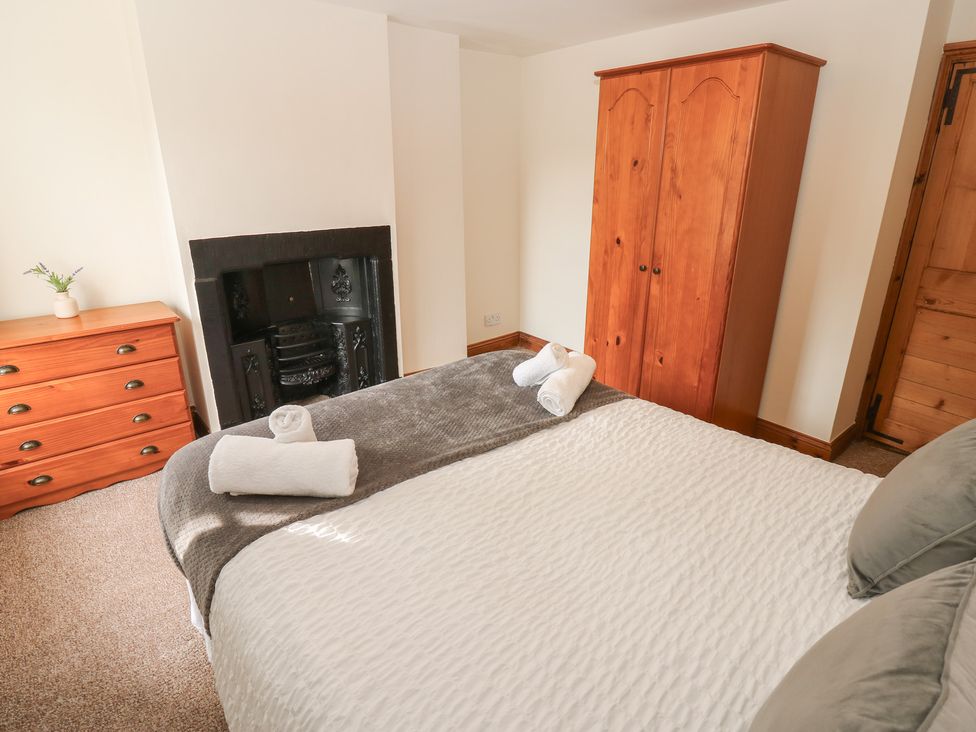 A bedroom with a bed and wardrobe at Kirkgate Cottage in Cockermouth
