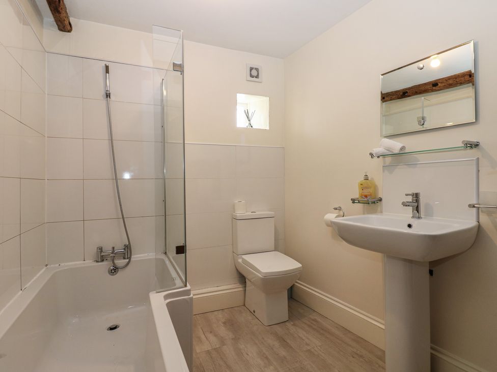 A bathroom with a shower and bathtub at Kirkgate Cottage in Cockermouth