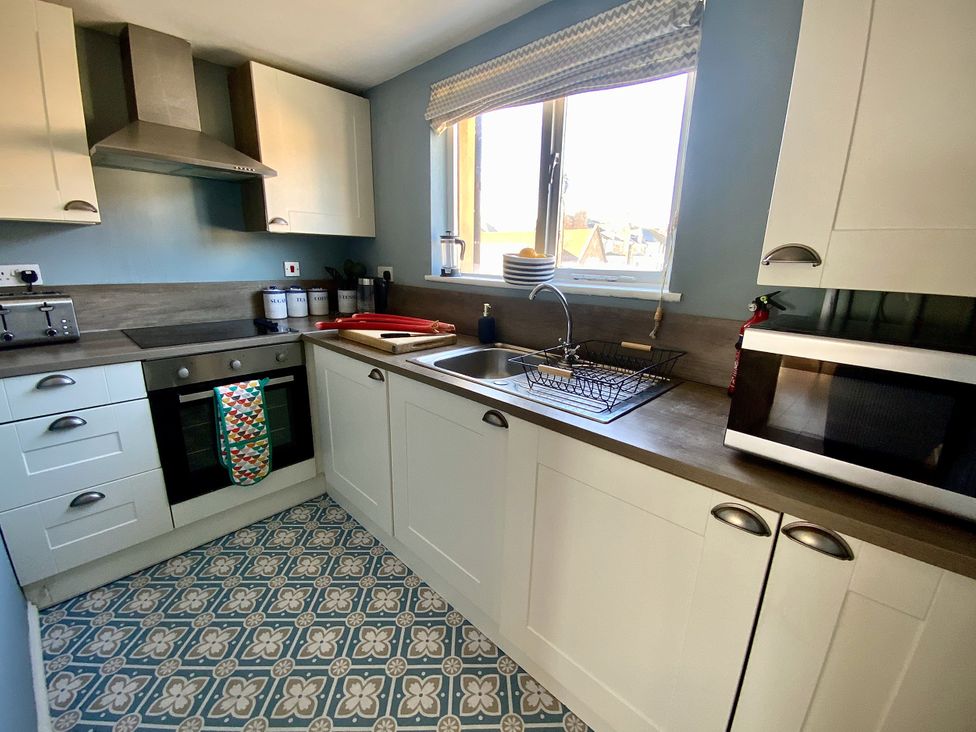 A kitchen with a sink, oven, and microwave at Corner View in Broadstairs