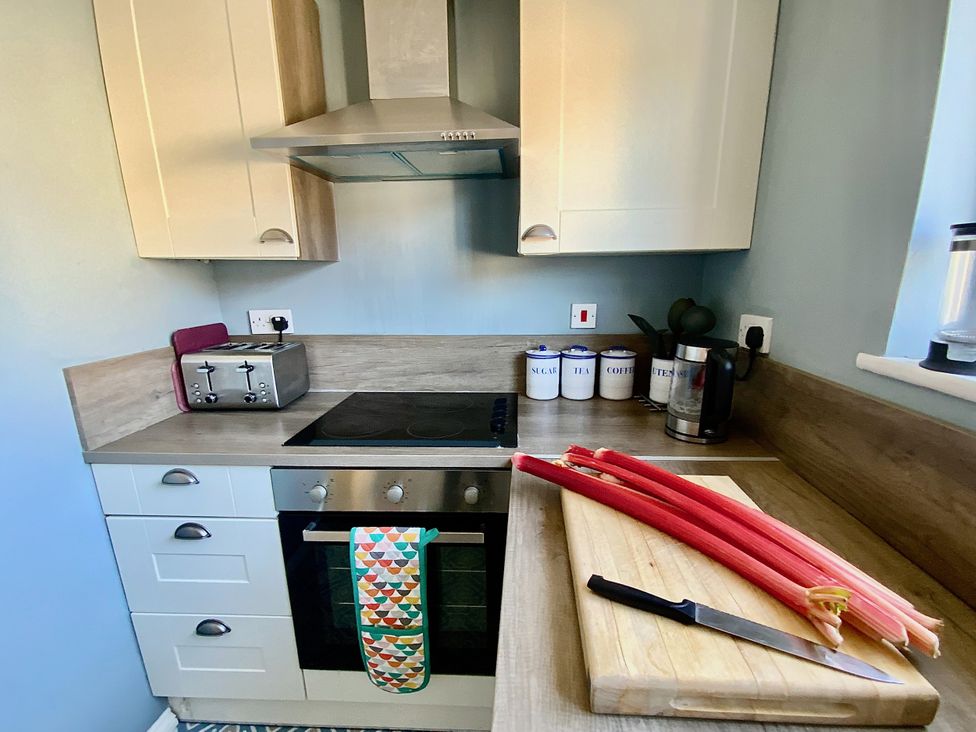 A kitchen with an oven, toaster, and rhubarb on a cutting board at Corner View in Broadstairs
