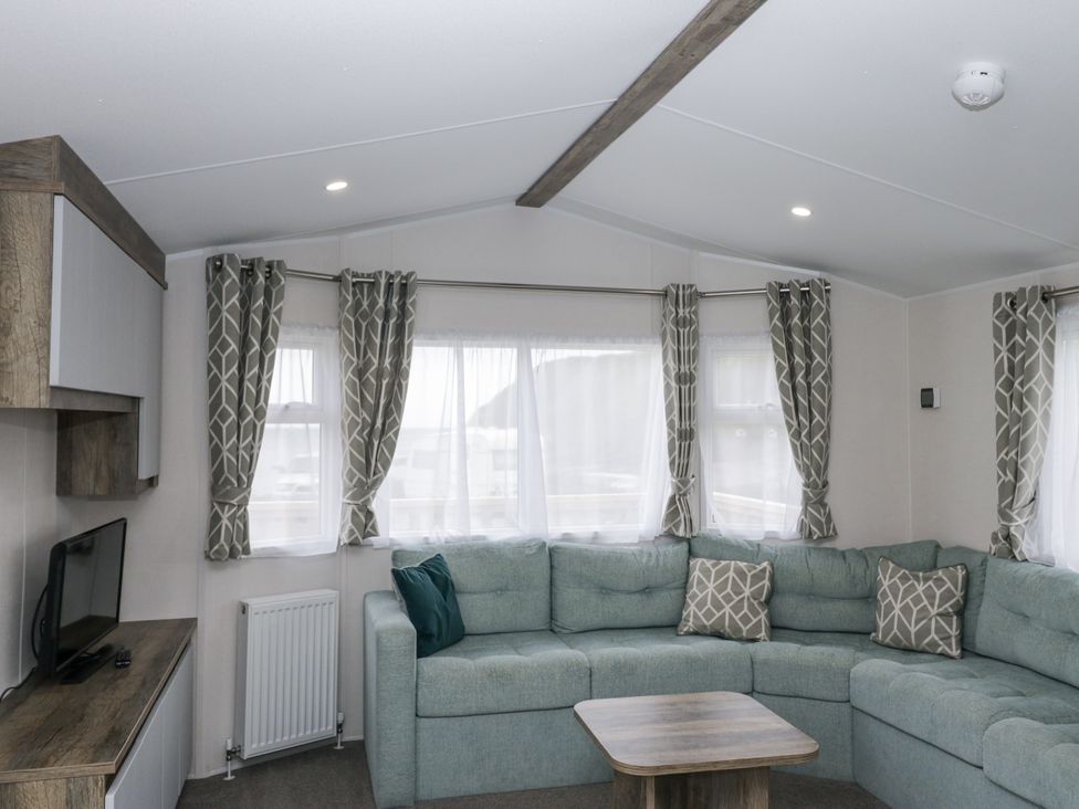 A living room with a sofa and television at Puffin in St Bees