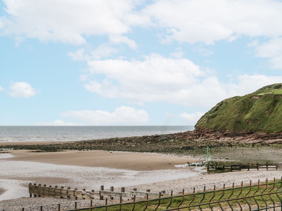 An outdoor view of a beach and cliff at Puffin in St Bees