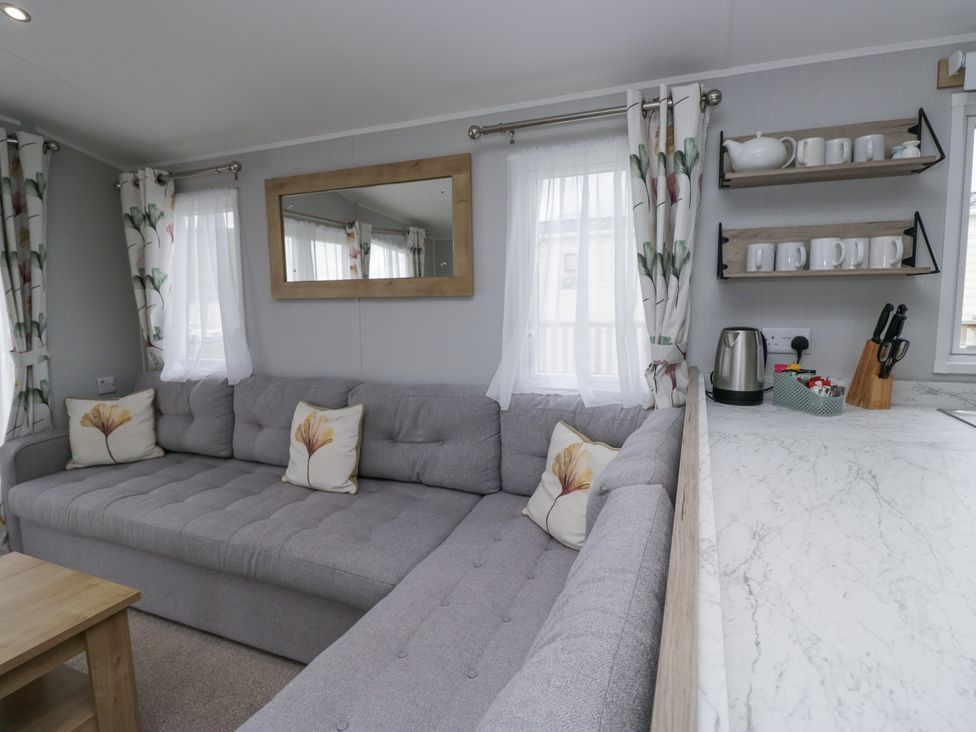 A living room with a sofa and coffee table at Sandpiper in St Bees