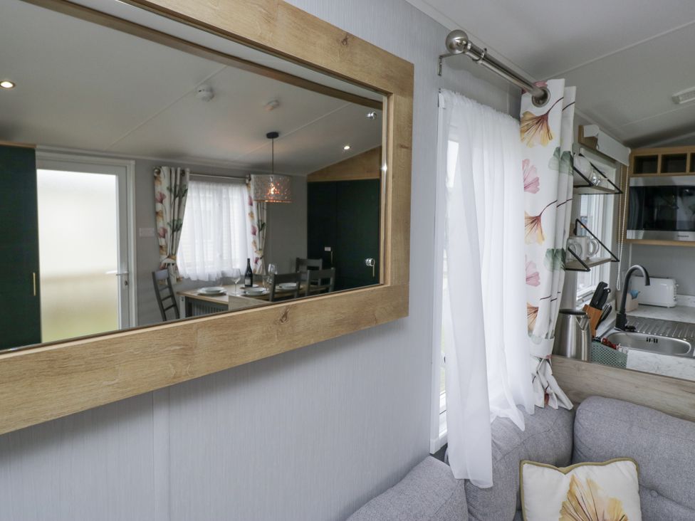 A living room with a dining area and kitchen at Sandpiper in St Bees