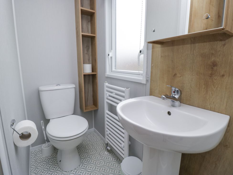 A bathroom with a toilet and sink at Sandpiper in St Bees