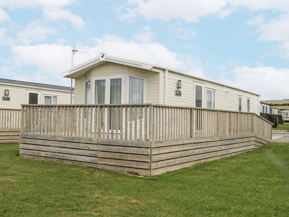 A mobile home with a wooden deck located at Sandpiper in St Bees
