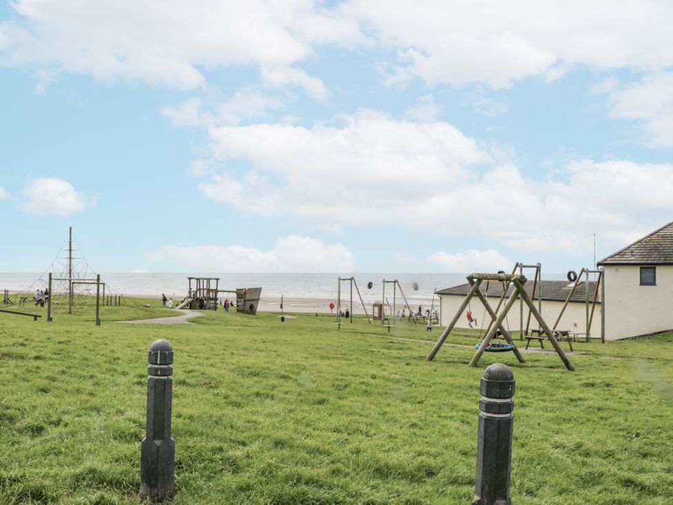 A playground with swings and climbing structures at Sandpiper in St Bees
