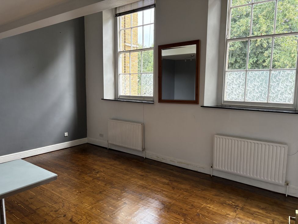 A living room with windows and a mirror at Woolwich Apartment in Woolwich