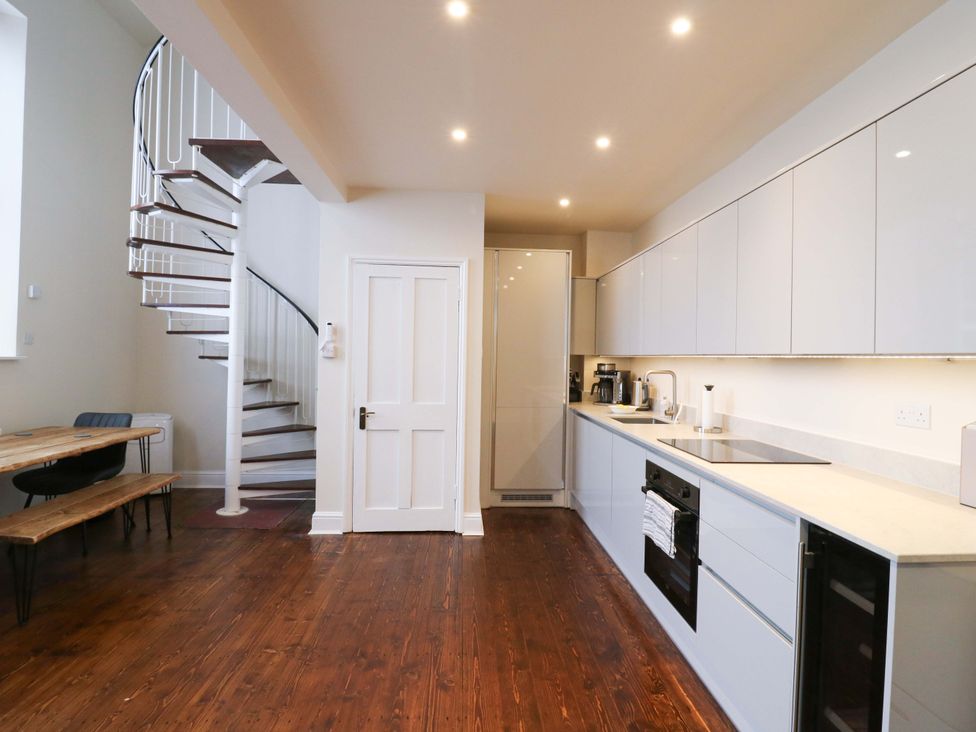 A kitchen with a staircase and dining area at Woolwich Apartment in Woolwich