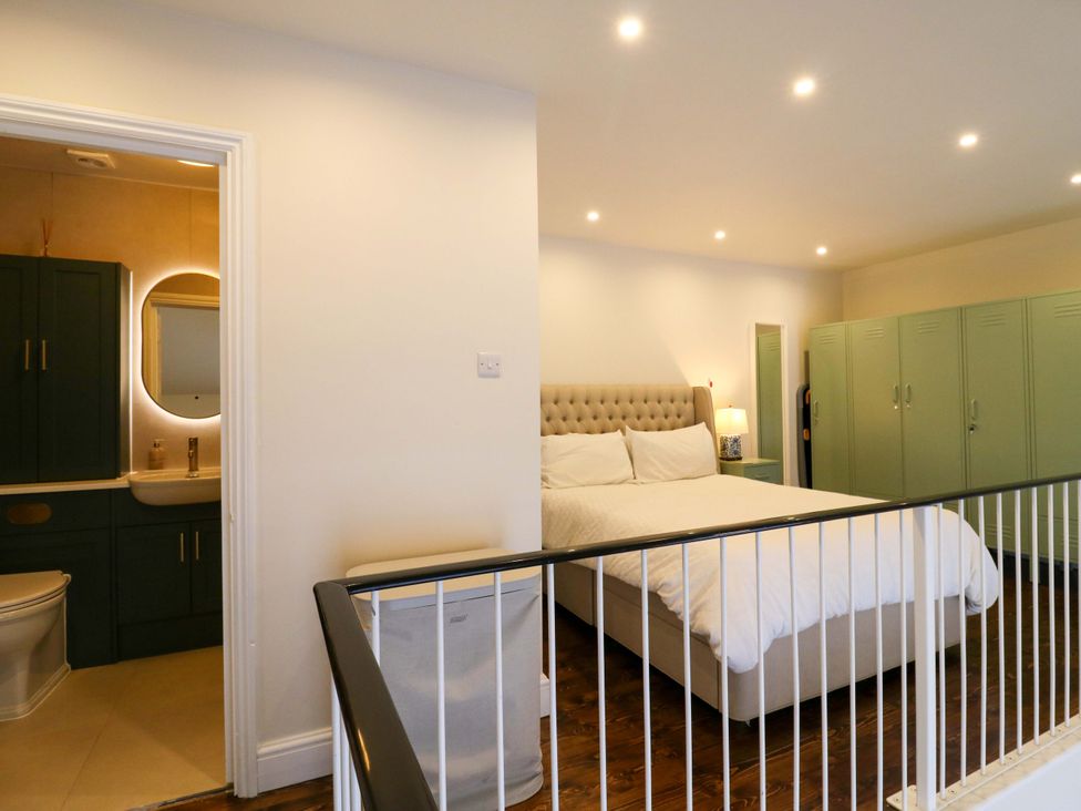 A bedroom featuring a bed, nightstand, and attached bathroom in Woolwich Apartment Woolwich