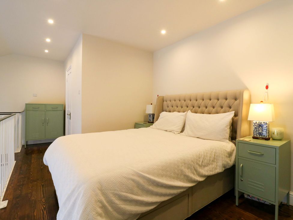 A bedroom with a bed and nightstands at Woolwich Apartment in Woolwich
