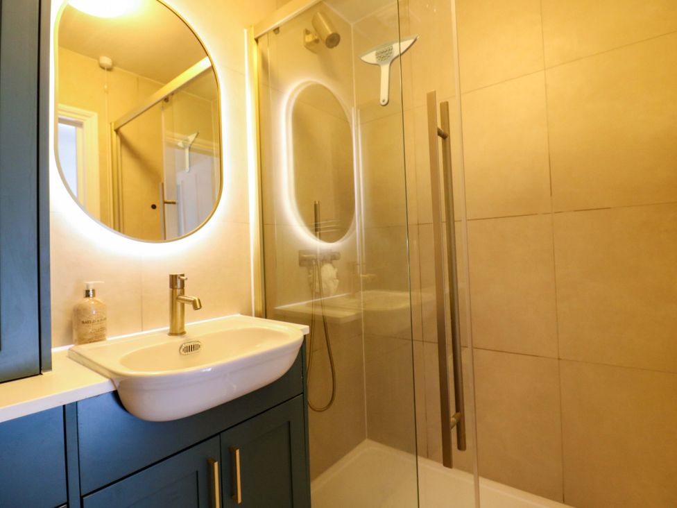 A bathroom with a shower and a vanity sink at Woolwich Apartment in Woolwich