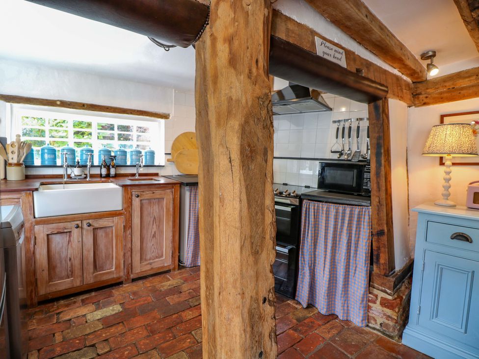 A kitchen with wooden cabinets and a sink at Bank House