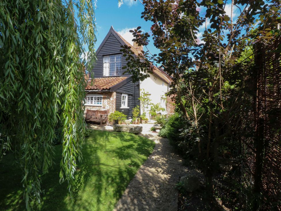 A garden with a pathway and house at Bank House