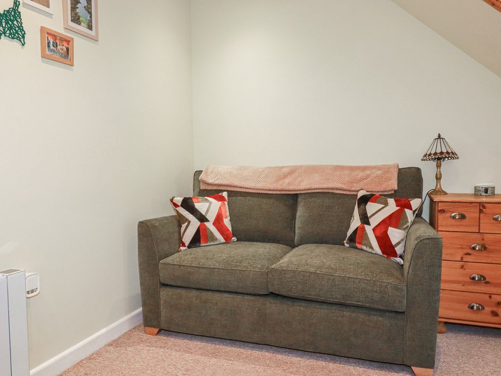 A living room with a sofa and decorative items at Mini Mena in St Austell