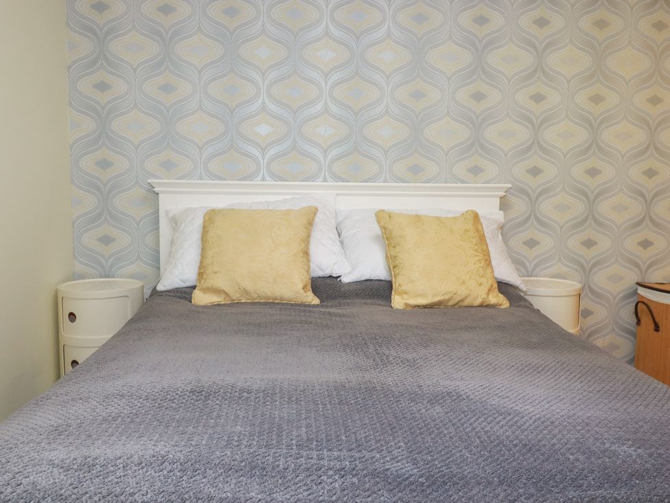 A bedroom with a bed and pillows at Mini Mena in St Austell